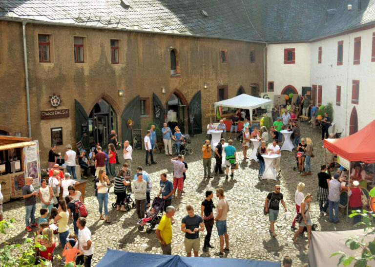 Gäste stehen auf einem Burg-Innenhof. Anlass ist das EuroBean Chocolate Festival 2017.